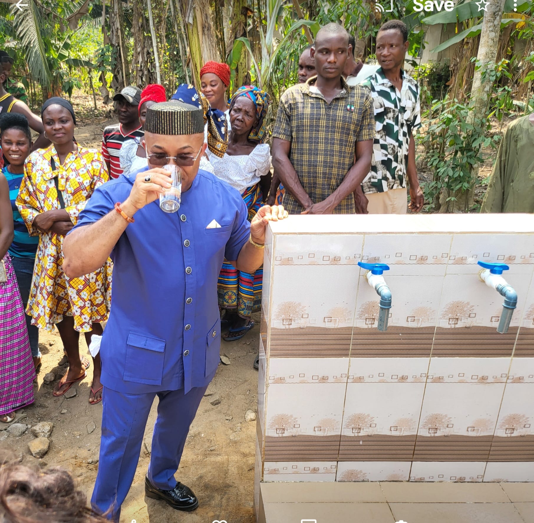 Reverend Fr Godwin having a glass of water from the tap